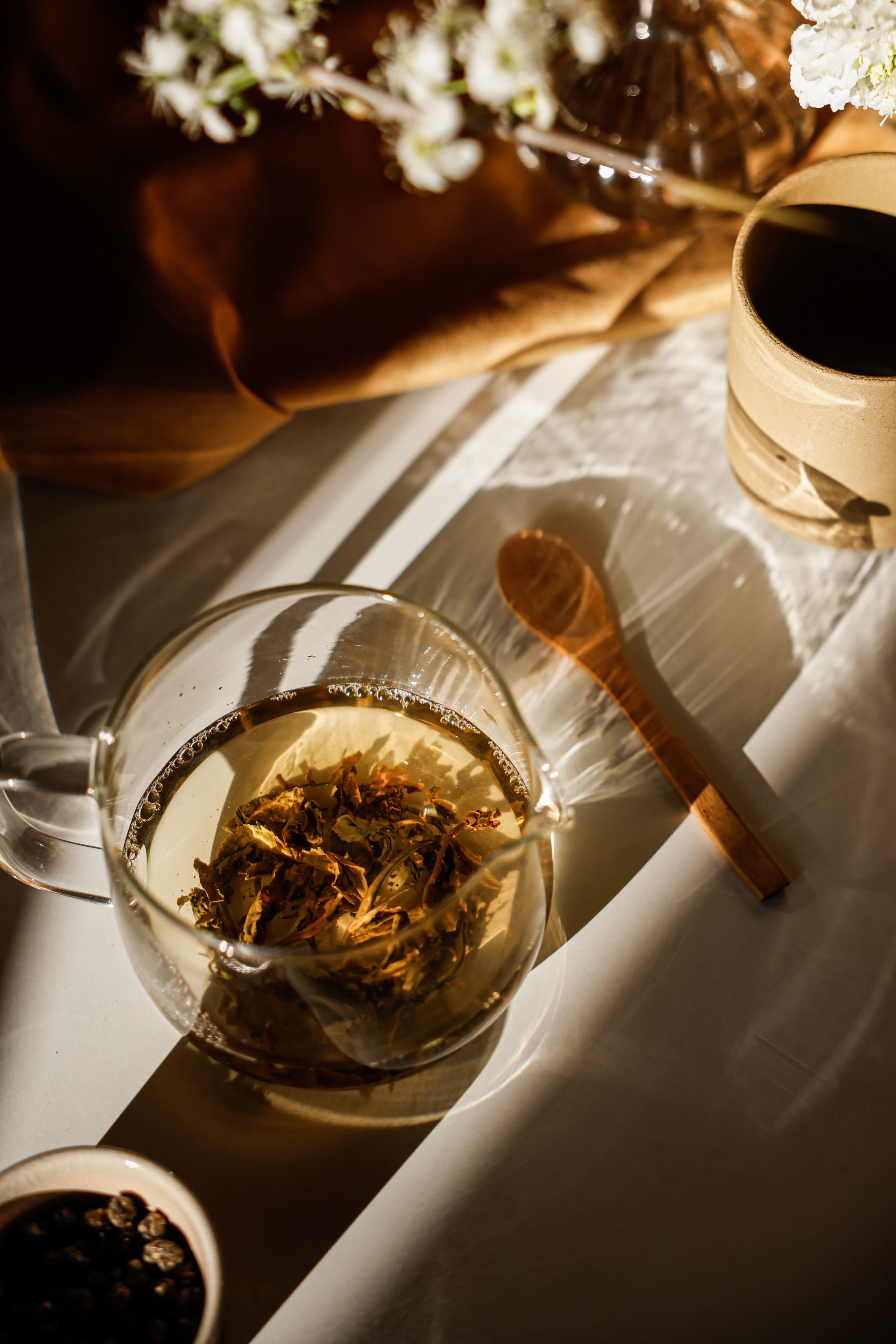 Loose leaf herbal tea steeping in a glass cup
