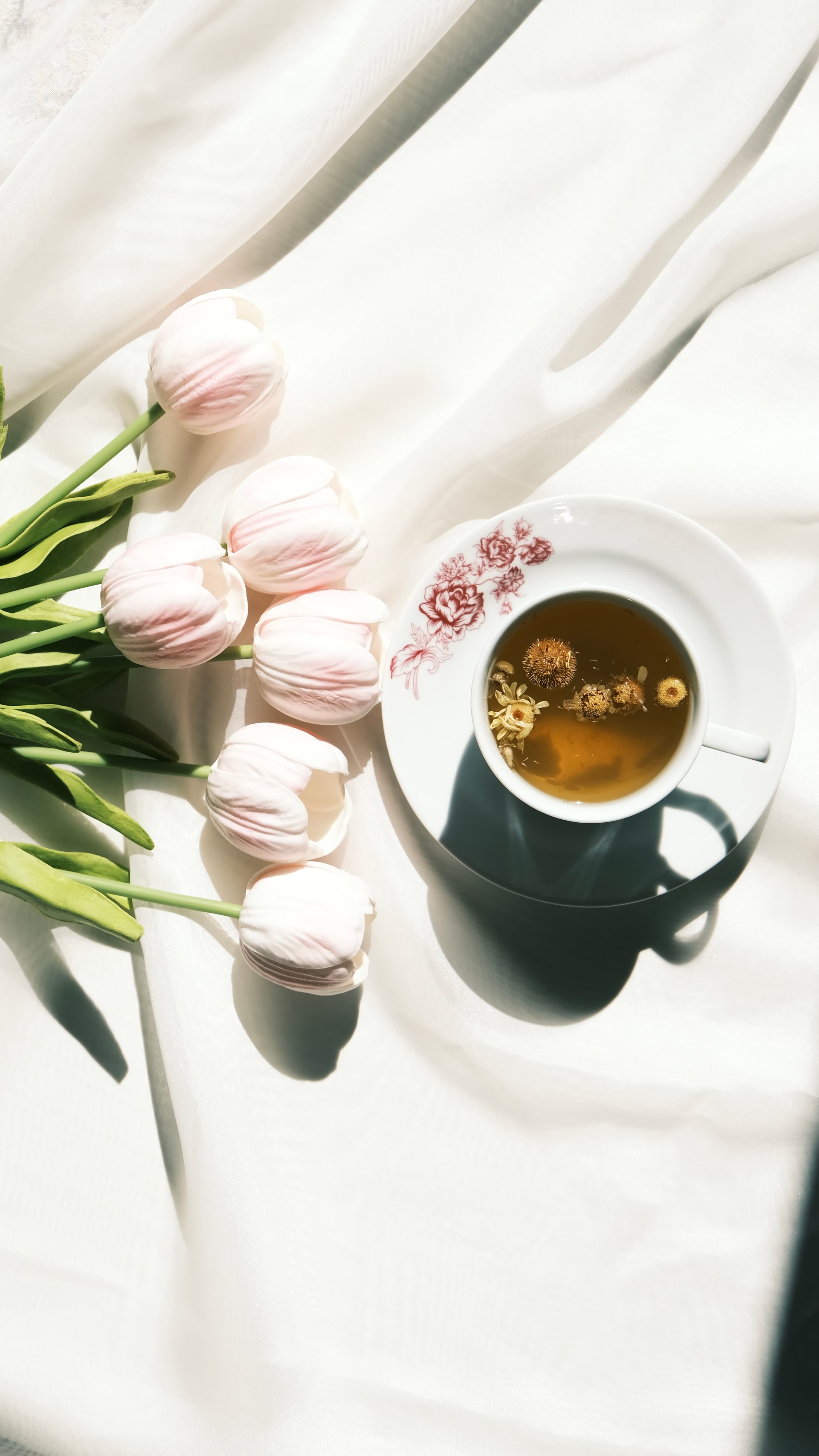 A cup of golden herbal tea with dried flowers